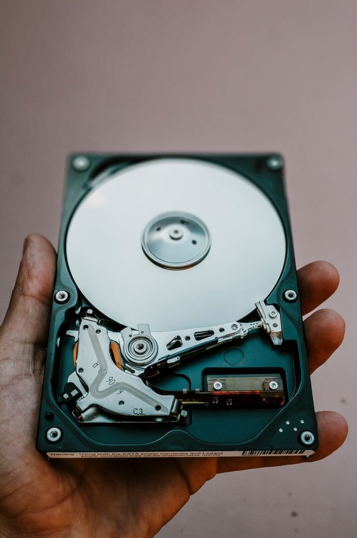 services-bg Close-up view of an open hard drive held in a hand, illustrating data storage technology.