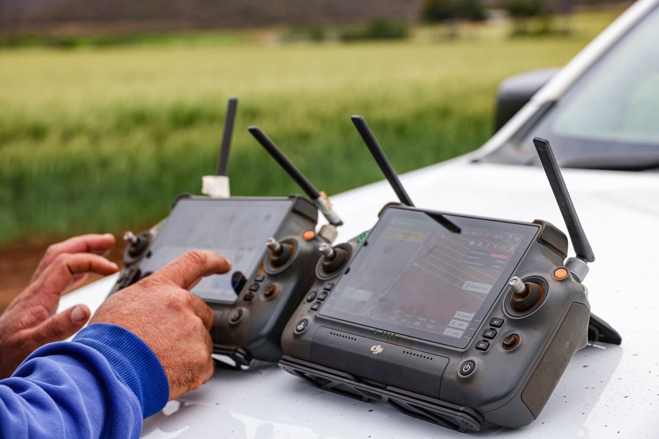 Crafting Captivating Headlines: Your awesome post title goes here Close-up of farmers using drone controllers on a farm for precision agriculture.