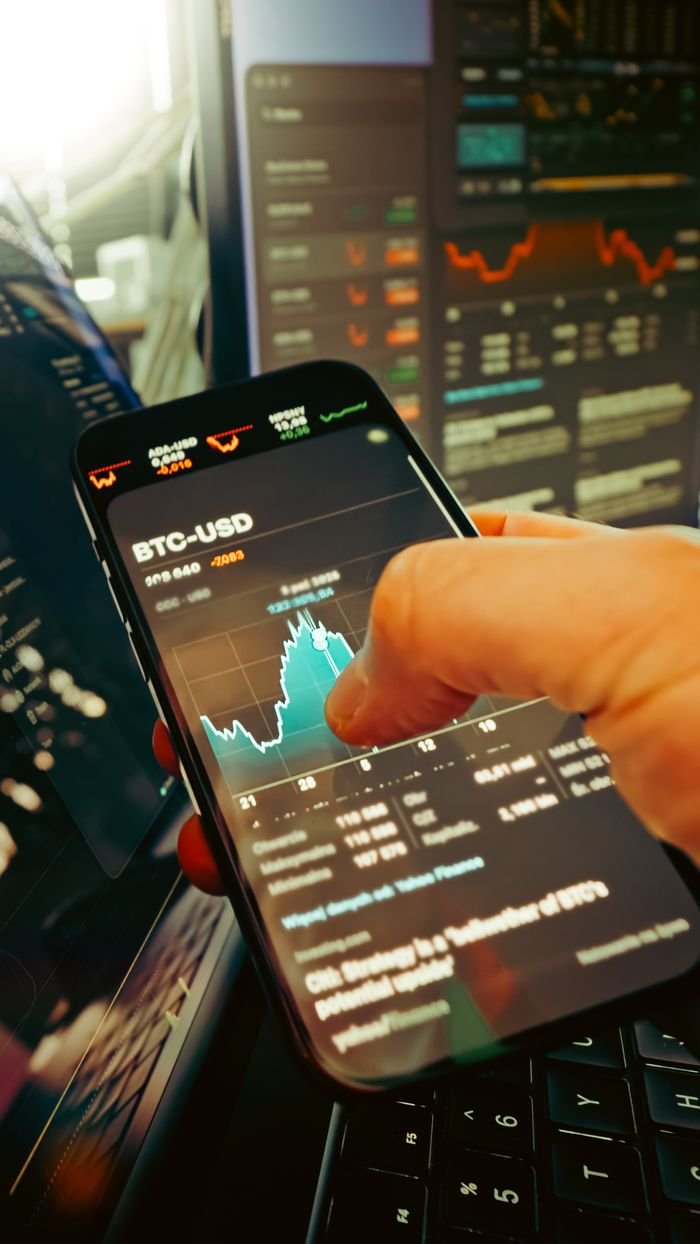The Art of Drawing Readers In: Your attractive post title goes here A hand holds a smartphone displaying BTC-USD chart amidst digital trading screens, highlighting crypto finance.